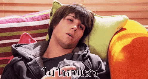 a man is laying on a couch with a foreign language written on the bottom right
