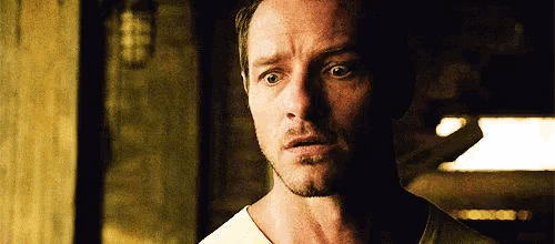 a close up of a man 's face with a beard and a white shirt .