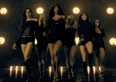 a group of women are dancing in front of lights