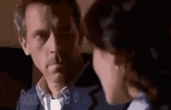 a man and a woman are sitting next to each other and looking at each other .
