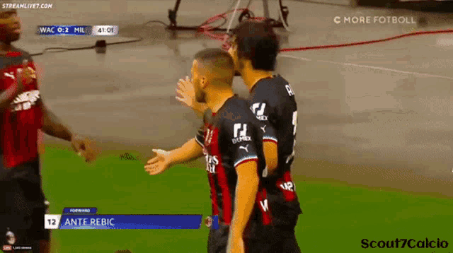 two soccer players are hugging each other on the field .