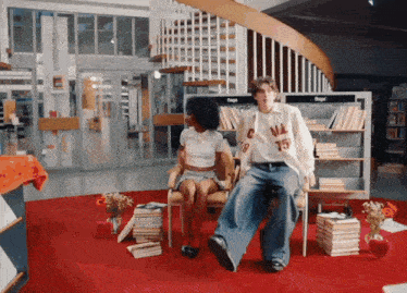 a man wearing a shirt with the number 15 on it sits next to a woman in a chair