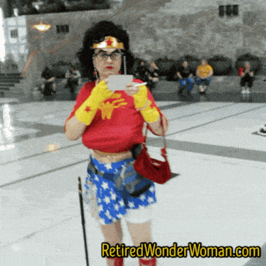 a woman in a wonder woman costume is holding a piece of paper
