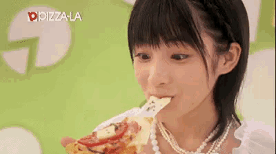 a woman is eating a slice of pizza with the word pizza la on the bottom