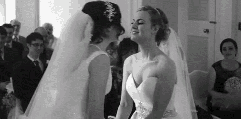 two brides are standing next to each other at their wedding ceremony .