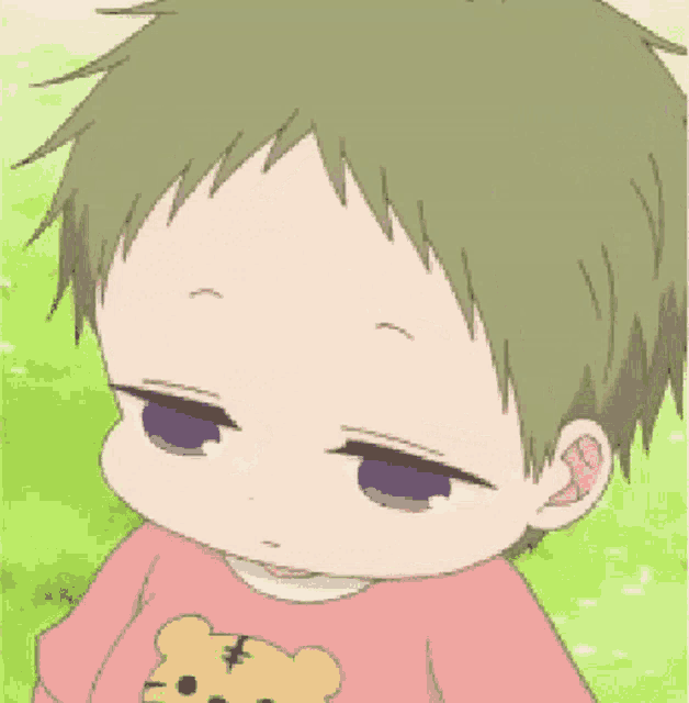 a little boy wearing a pink shirt with a teddy bear on it .