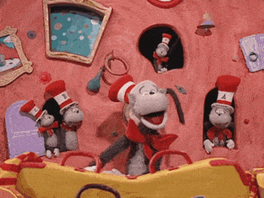 the cat in the hat is wearing a red hat with the letter b on it