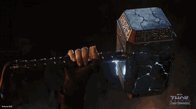 a woman in a thor costume is holding a hammer in her hand