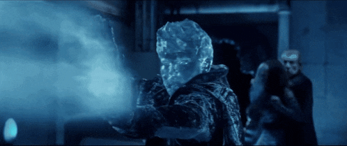 a man with ice on his face is holding a gun in a dark room