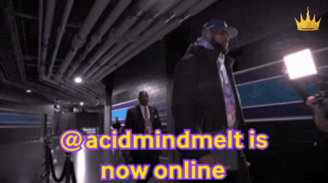 a man is walking down a hallway with the words acidmindmelt is now online