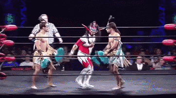 a wrestler in a red and white outfit is fighting another wrestler