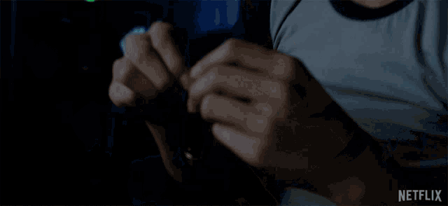 a person holding a knife in their hand with a netflix logo on the bottom