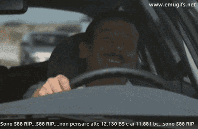 a picture of a man driving a car with the website www.emugifs.net in the corner