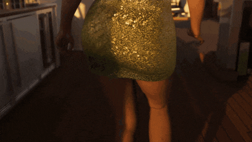 a woman in a green dress is standing on a deck