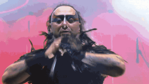 a man with a beard and black paint on his face is holding a sword