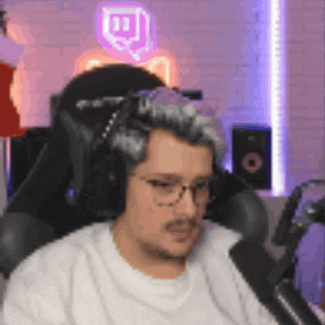 a man wearing headphones is sitting in front of a microphone .