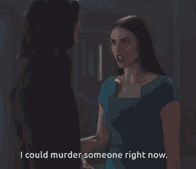 a woman in a blue dress is talking to a man in a red shirt