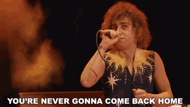 a man singing into a microphone with the words " you 're never gonna come back home " next to him