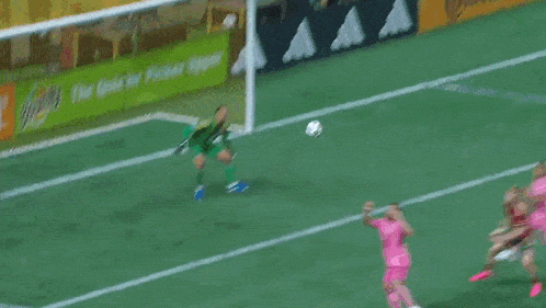 a goalie in a green jersey with the number 11 on it is laying on the field