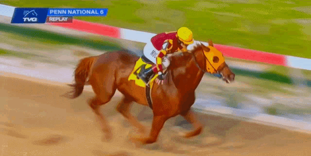 a jockey rides a horse in a penn national race