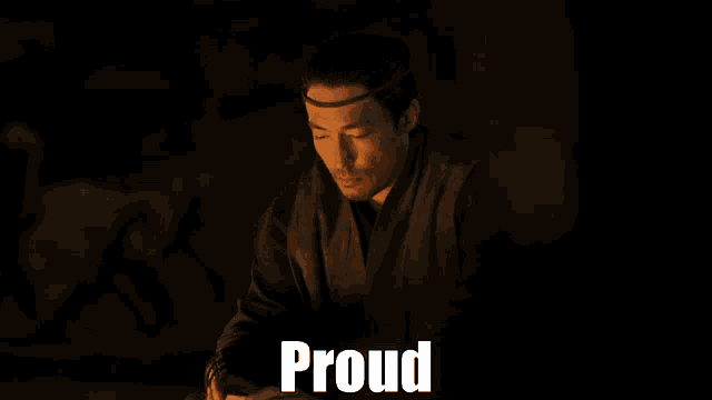 a man in a dark room with the word proud written above him