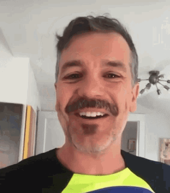 a man with a mustache and a beard is smiling .