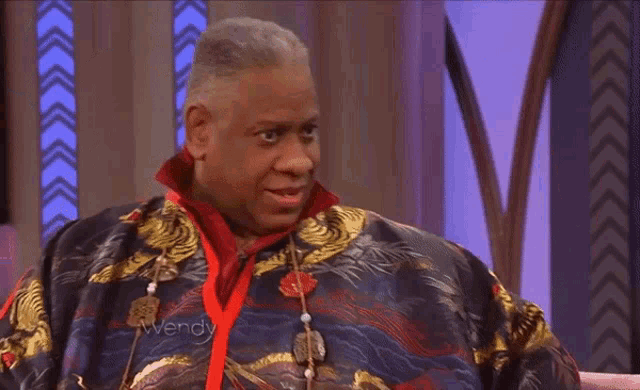 a man wearing a jacket that says ' avery ' on it sits in a chair