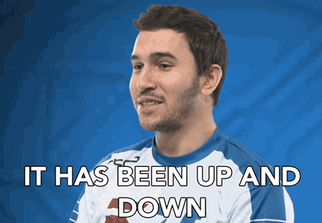 a man in a blue and white shirt with the words it has been up and down above him