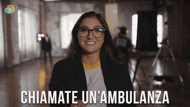 a woman wearing glasses is smiling with the words chiamate un'ambulanza behind her