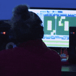 a person wearing headphones is looking at a computer screen with a green background and the letters g and i on it