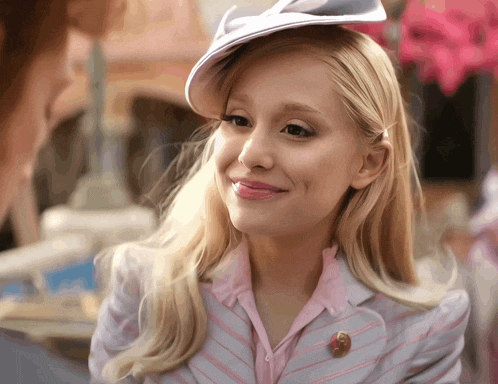 a woman wearing a white hat and a pink striped jacket