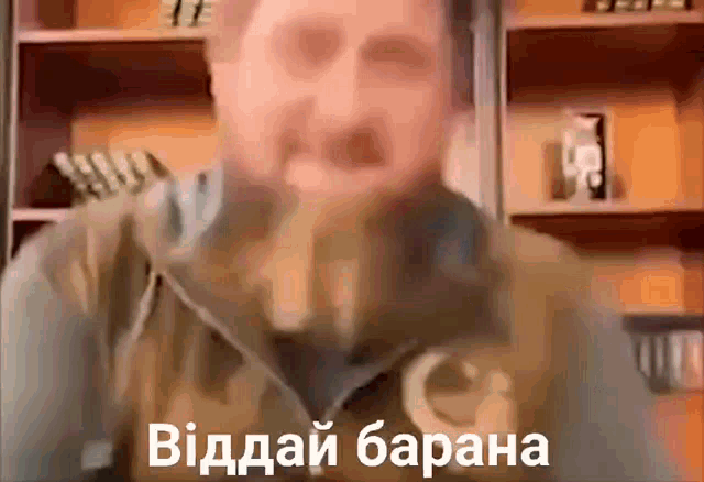 a blurry picture of a man with a foreign language written on the bottom of his face