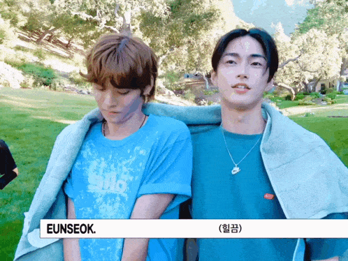two young men are standing next to each other and one has the name eunseok on his shirt