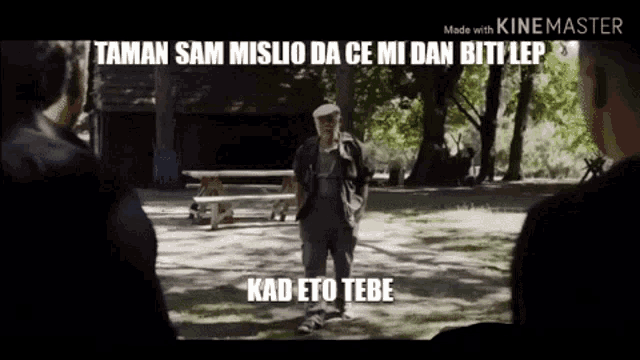 a man in a hat is standing in a park talking to two men .