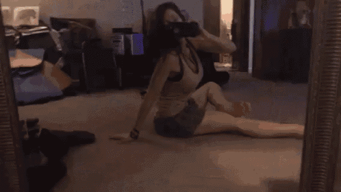 a woman sits on the floor in front of a mirror