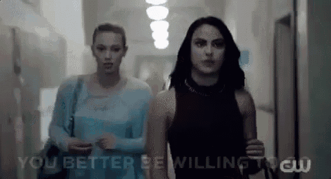 two women are walking down a hallway with the words `` you better be willing to '' written on the bottom .