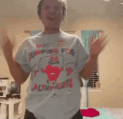 a woman wearing a t-shirt that says jumping for saltines is dancing in a bedroom .