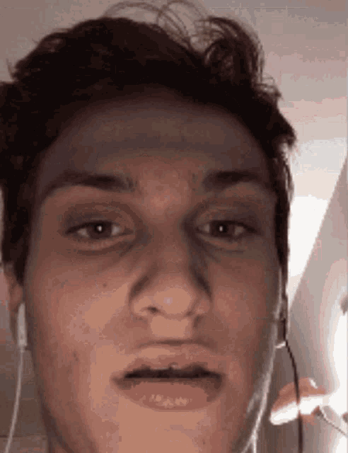 a close up of a man 's face with earphones on