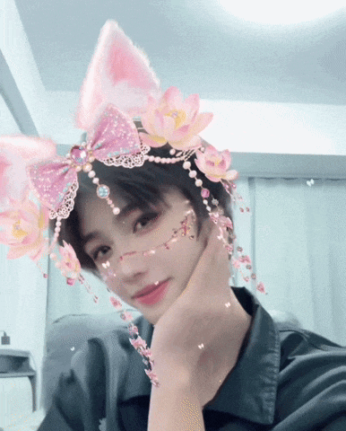 a girl wearing a headband with pink flowers and bows on it