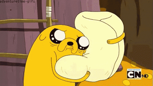 a cartoon character from adventure time is holding a pillow in his mouth