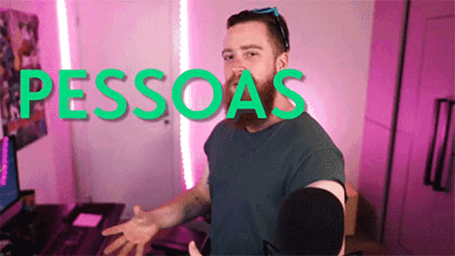 a man with a beard is standing in front of a pink wall with the word pessoas written on it