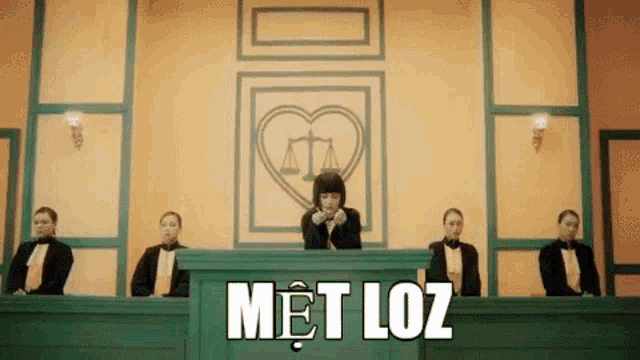 a woman is sitting at a judge 's bench in a courtroom surrounded by lawyers .