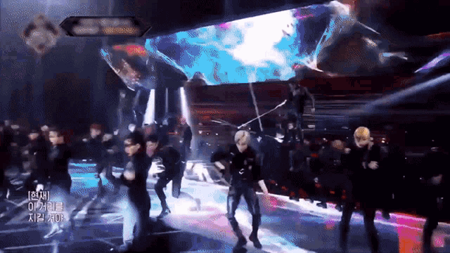 a group of people are dancing on a stage with a sign above them that says ' a '