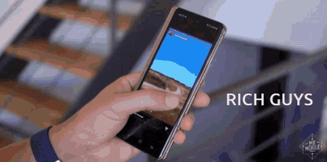 a person holding a cell phone with the words rich guys written on the bottom