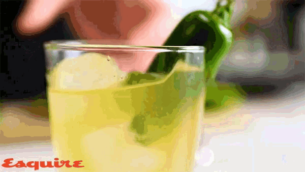 a close up of a drink with the word esquire on the bottom right
