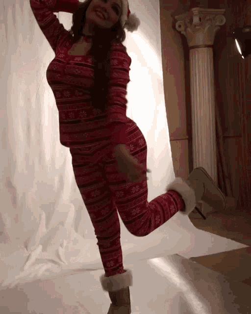 a woman is wearing a santa hat and a pajama set