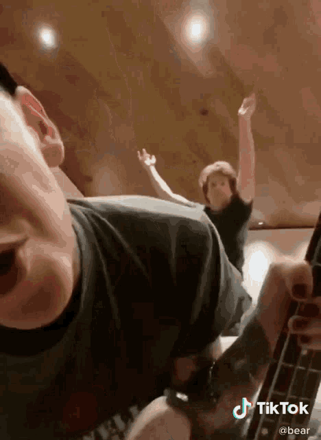 a man playing a guitar with a tiktok watermark on the bottom right