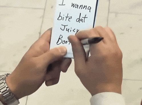 a person is writing on a note that says i wanna bite dat juicy boot