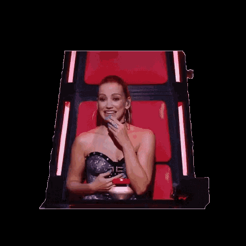 a woman sitting in a red chair with her hand up