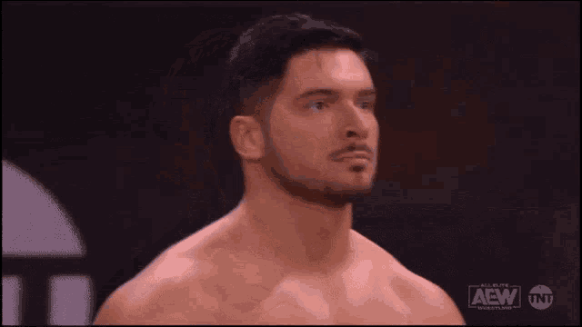 a shirtless man is standing in front of a sign that says aew tnt